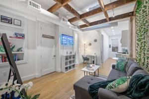 a living room with a couch and a tv at Chic Industrial Home In City Center in Hoboken