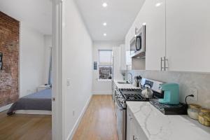 a kitchen with a stove top oven next to a bed at Chic Industrial Home In City Center in Hoboken