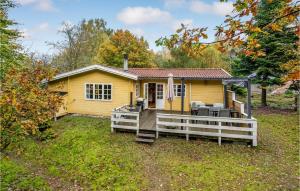 une petite maison jaune avec une terrasse couverte dans l'établissement 3 Bedroom Cozy Home In Brkop, à Børkop
