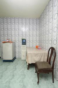 a room with a table and a chair and a refrigerator at Kost&Guesthouse Tirza in Banyuwangi
