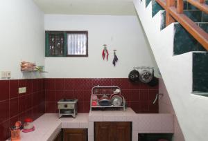 a small kitchen with red tiles on the wall at Kost&Guesthouse Tirza in Banyuwangi