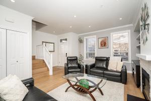 uma sala de estar com mobiliário de couro preto e uma lareira em Comfortable and Modern Rowhouse Perfect for BC Escapade, air conditioned em Langley