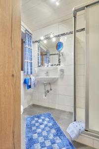 La salle de bains est pourvue d'un lavabo et d'une douche. dans l'établissement Gästehaus Sonnenbichl, à Berchtesgaden