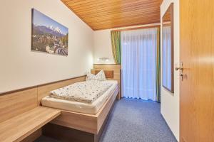 Schlafzimmer mit einem Bett und einem Fenster in der Unterkunft Gästehaus Sonnenbichl in Berchtesgaden