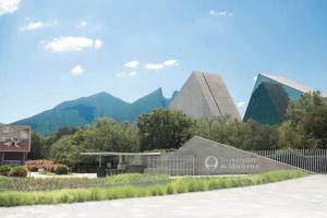 a building with a sign in front of some mountains at Artesanias de Mexico (centrica, privada, comoda). in Monterrey