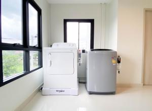 two refrigerators are sitting in a room with a window at Rest Suvarnabhumi in Samutprakarn