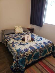 a bedroom with a bed with a colorful comforter at Artesanias de Mexico (centrica, privada, comoda). in Monterrey