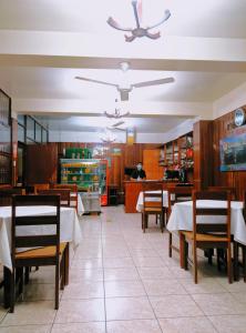 a restaurant with tables and chairs and a chef in the background at Hospedaje El Virrey in Pucallpa