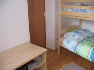 Cette petite chambre comprend des lits superposés et une table. dans l'établissement Apartma Jeglic, à Bohinj
