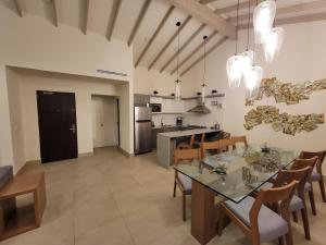 a kitchen and dining room with a glass table and chairs at Villa con jacuzzi privado en Descanso in Primo Tapia