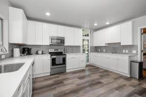 a large white kitchen with white cabinets and appliances at Entire Main level of Beautiful Historic Home in Spokane