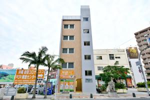 a tall building with palm trees in front of it at メイスン倶楽部 501 in Asato