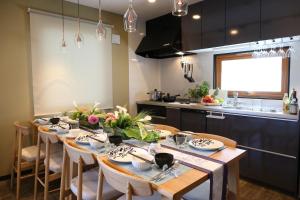 een keuken met een tafel met borden en bloemen erop bij HOUSE HOTEL MASHU - Vacation STAY 88249 in Sapporo