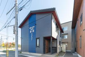 een gebouw met een bord aan de zijkant bij HOUSE HOTEL MASHU - Vacation STAY 88249 in Sapporo
