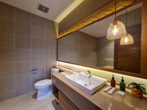 bagno con lavandino, servizi igienici e specchio di Parlezo by Kagum Hotels a Labuan Bajo