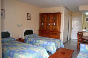 a bedroom with two beds and a wooden cabinet at Apartamentos Minerva Jupiter in Benalmádena