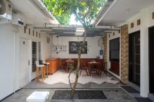 un patio con una mesa y un árbol en una habitación en RedDoorz Syariah near Kampus UNSOED Purwokerto, en Banyumas