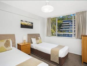 a hotel room with two beds and a window at Park Towers-Goodwin Towers Holiday Units in Gold Coast