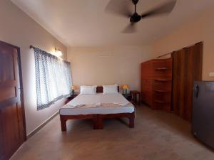 - une chambre avec un lit et un ventilateur de plafond dans l'établissement OmBodhi Retreat, à Kumta