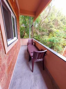 d'un balcon avec un banc pourpre et une fenêtre. dans l'établissement OmBodhi Retreat, à Kumta