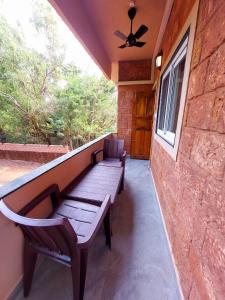 a bench sitting on the porch of a house at OmBodhi Retreat in Kumta