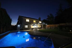 uma casa com piscina à noite em @ Marbella Lane - 4BR Cozy home in SJ Pool em San José