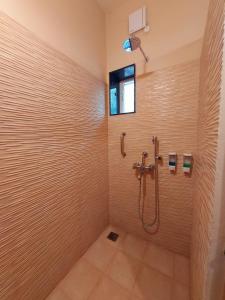 La salle de bains est pourvue d'une douche et d'une fenêtre. dans l'établissement OmBodhi Retreat, à Kumta