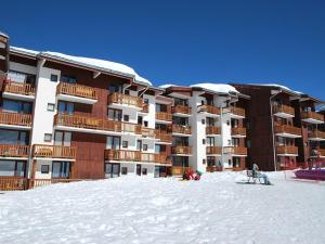 a large building in the snow with people sitting in front of it at Studio La Plagne, 1 pièce, 3 personnes - FR-1-351-23 in La Plagne