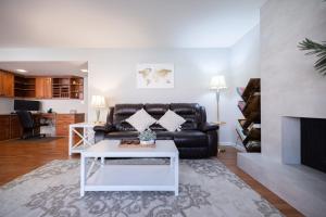 uma sala de estar com um sofá de couro preto e uma mesa em @ Marbella Lane - 4BR Cozy home in SJ Pool em San José