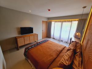 1 dormitorio con 1 cama grande y TV en Parlezo by Kagum Hotels en Labuan Bajo