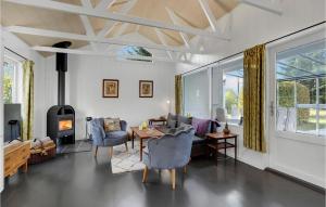 sala de estar con mesa, sillas y chimenea en Stunning Home In Mern With Kitchen, en Mern