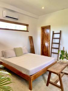a bed in a room with two chairs and a ladder at Secret Spot Siargao in General Luna