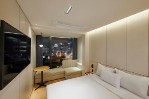 a bedroom with a bed and a table and a window at N285 Hotel Insadong in Seoul