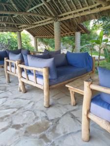 a blue couch sitting under a roof on a patio at Marijani Holiday Resort in Watamu
