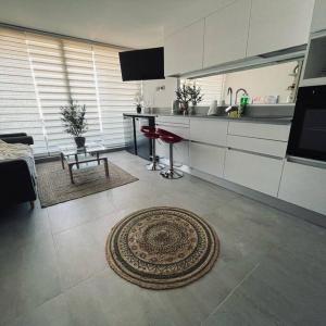 cocina con mesa y alfombra en el suelo en Apartamento Reñaca Live, en Viña del Mar