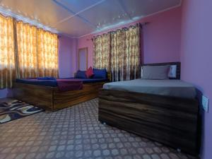 a bedroom with two twin beds and a window at Wind Valley Homestay in Pelling