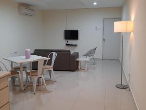 uma sala de estar com uma mesa e cadeiras e um sofá em Laguna2, Marina Island Pangkor-Homestay Apartment em Kampong Batu Gajah