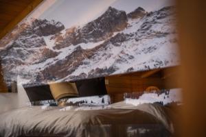 a bedroom with a snow covered mountain mural on the ceiling at VILLA HUNDERT Boutique Mountainscape in Engelberg