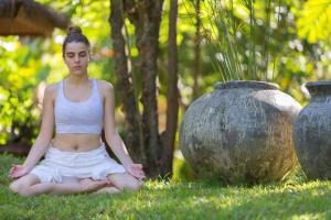 a woman sitting in the grass next to a vase at Zazen Boutique Resort & Spa in Bophut
