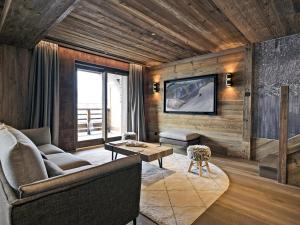 a living room with a couch and a tv on a wall at Appartement de luxe, skis aux pieds, Méribel - FR-1-613-39 in Méribel