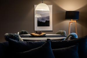 a living room with a table and a couch at VILLA HUNDERT Boutique Mountainscape in Engelberg