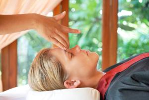 a woman laying on a bed with her hands on her head at Zazen Boutique Resort & Spa in Bophut