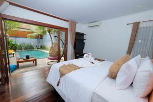 a bedroom with a bed and a swimming pool at Kayangan Villas Saba in Keramas