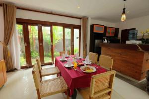 a dining room with a red table and chairs at Kayangan Villas Saba in Keramas