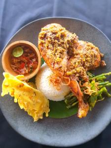 un plato de comida con arroz y carne y hortalizas en The Sagara Penida Nusa Penida en Nusa Penida