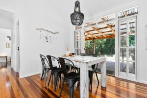 a dining room with a white table and black chairs at Bon Cottage in Woorim