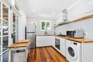 a kitchen with a refrigerator and a washer and dryer at Bon Cottage in Woorim