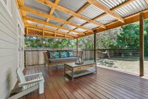 a covered porch with a couch and a table at Bon Cottage in Woorim +11 photos