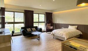 a bedroom with a bed and a chair and a table at Long Fu Hotel in Beigan