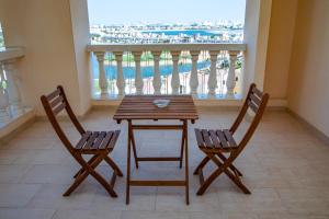 a table and two chairs in a room with a balcony at Hala Holiday Homes - Al Hamra Village, RAK in Ras al Khaimah